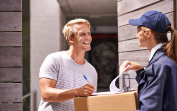 Delivery, courier and man sign documents, forms and application for package, parcel and box. Online shopping, ecommerce and people with paperwork for shipping, supply chain and distribution in home.